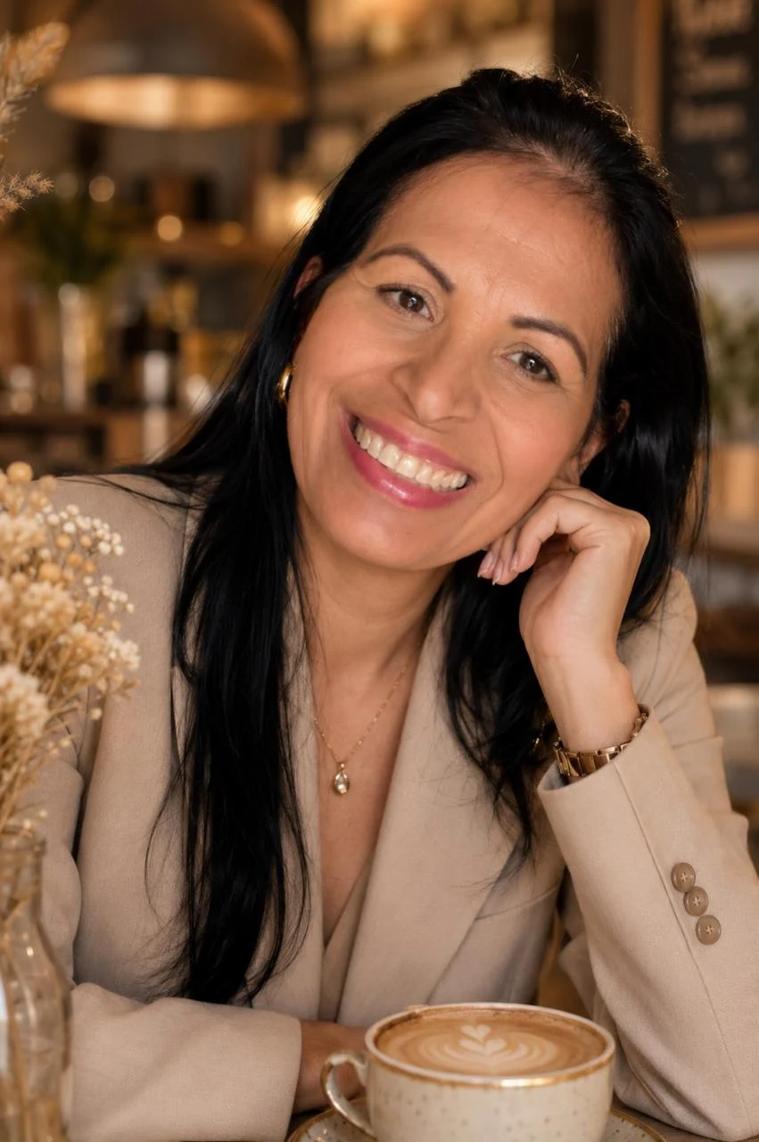 Tânia Grossi sorrindo, em sua fotografia original, usando um blazer bege